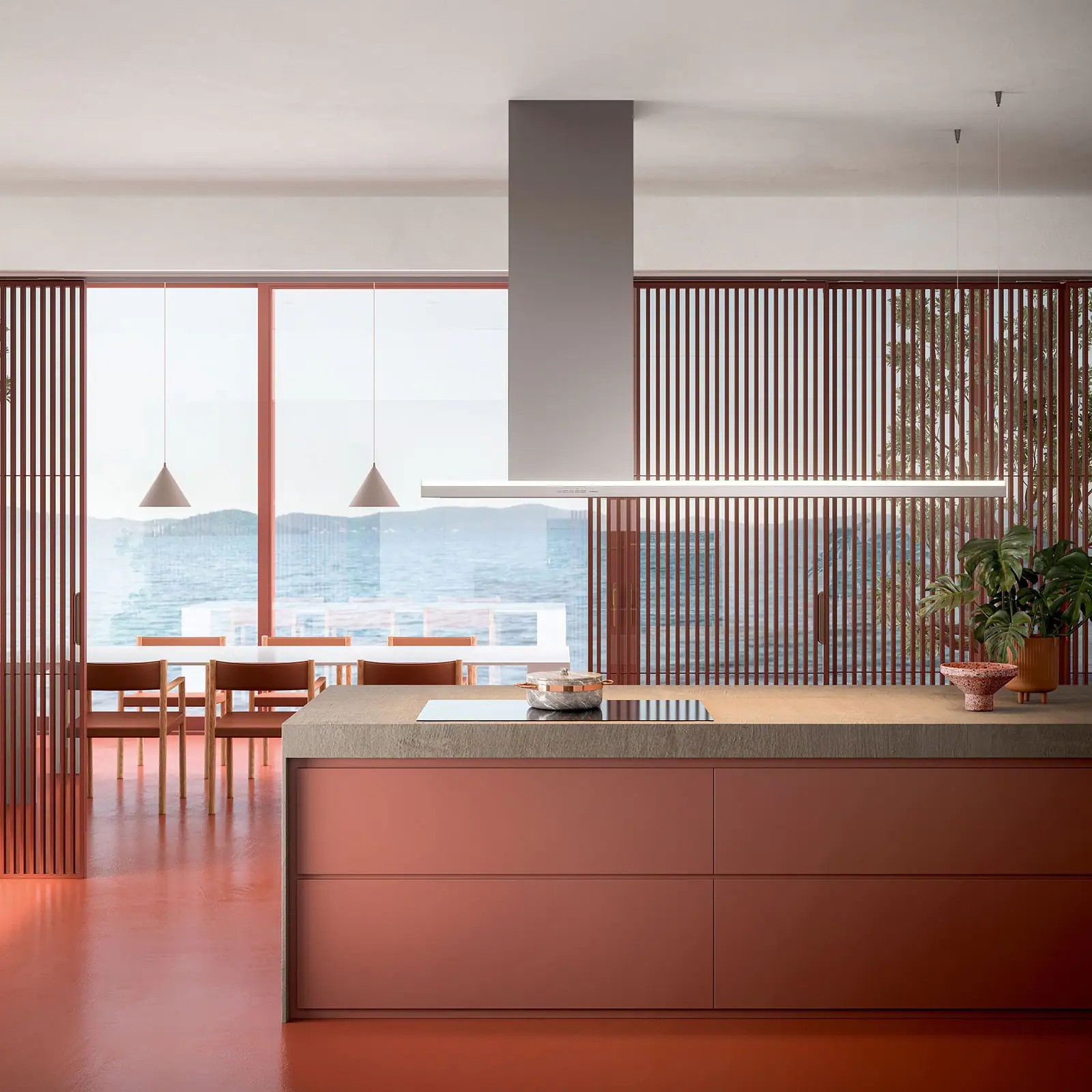 Falmec hood Lumen Island 175 Inox in a terracotta kitchen with sea view, showing the slim canopy and asymmetric left-side chimney