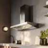Falmec Marte Pro 90 Inox wall hood in minimalist kitchen with walnut cabinets and concrete worktop