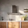 Falmec hood Marte Pro 90 Inox mounted in concrete-finish kitchen with steam rising over cooktop