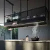 Falmec hood Spazio 180 Black showing Dynamic LED strip, tablet holder, and hanging plants over a cooktop in use