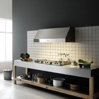 Falmec hood Zeus Pro 120 Inox installed in industrial-style kitchen with white tile backsplash and professional cooktops