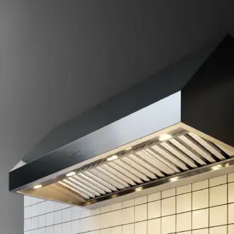 Falmec hood Zeus Pro 120 Inox installed in industrial-style kitchen with white tile backsplash and professional cooktops