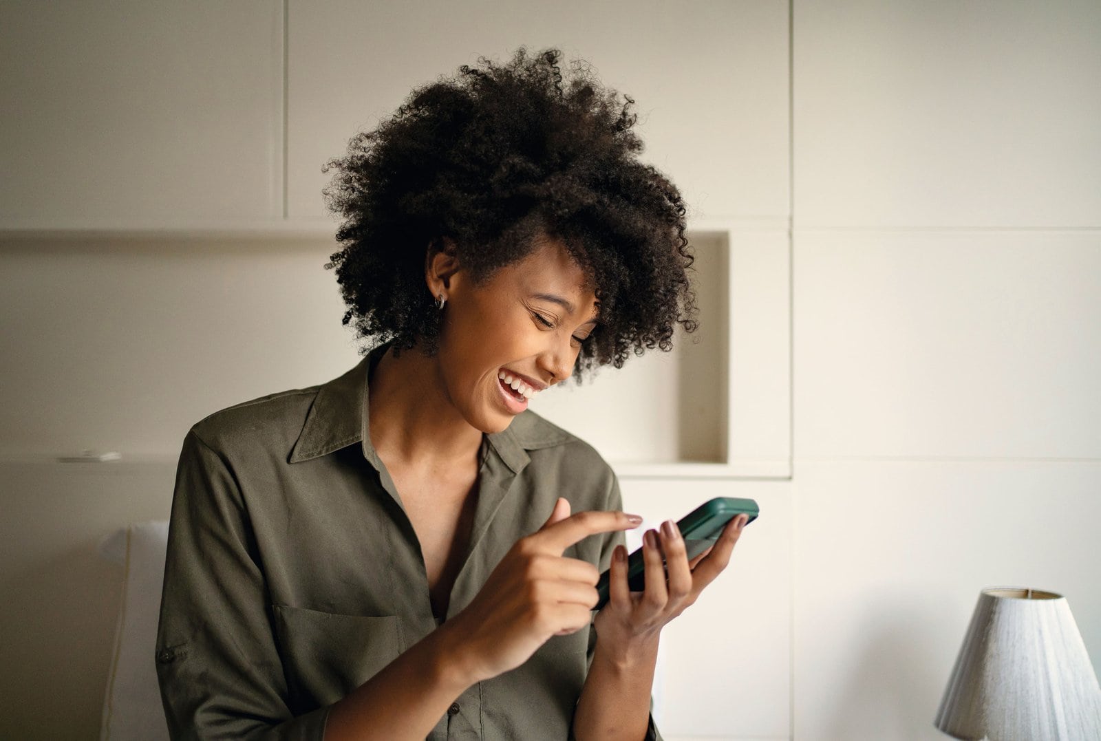 Woman smiling with the Miele app open on her phone
