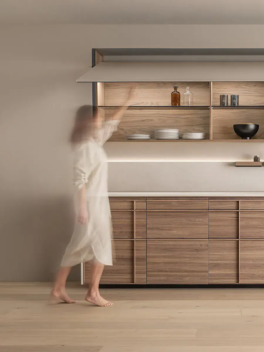 The Vela wall unit opening above an Archigraphica kitchen