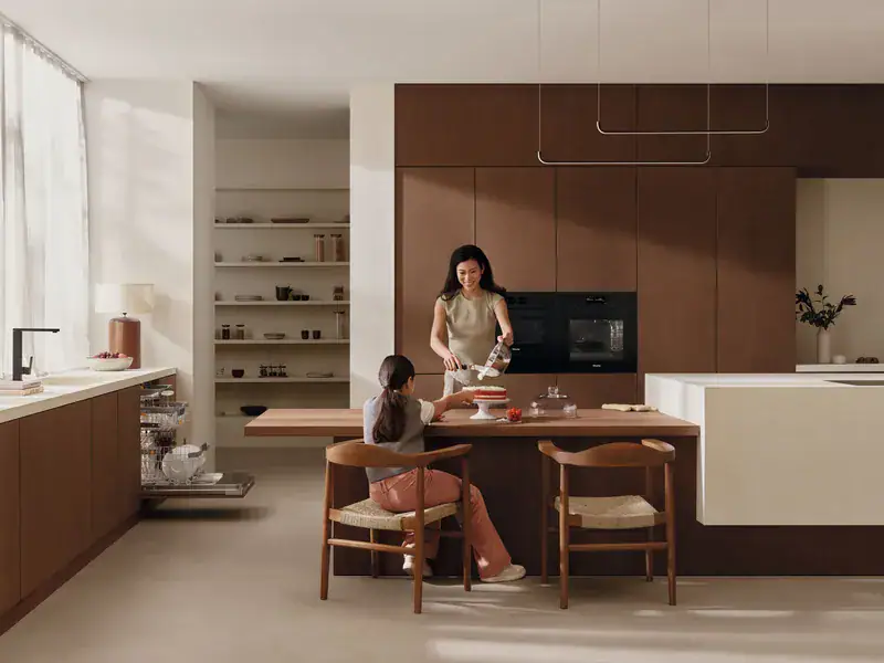 Mother and daughter baking in a kitchen fitted with Miele appliances